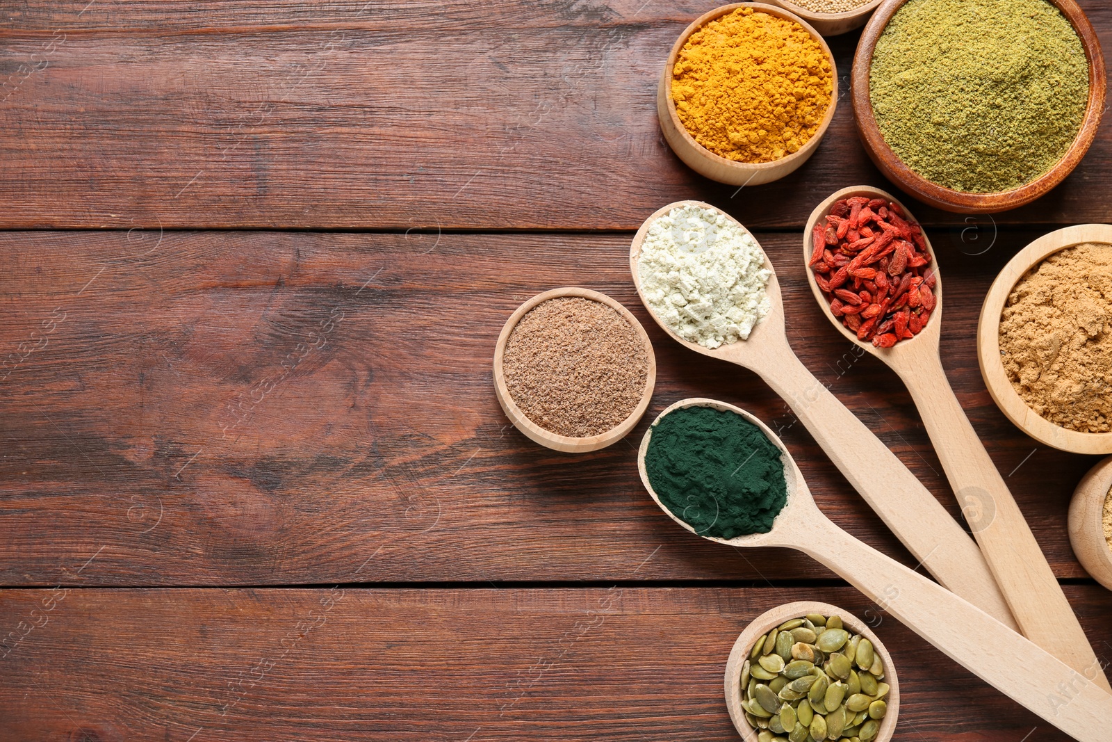 Different superfoods on wooden table, flat lay. Space for text Photo of Different superfoods on wooden table, flat lay. Space for text