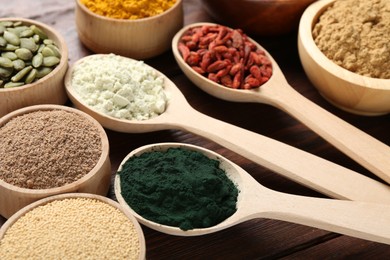 Photo of Different superfood products on wooden table, closeup