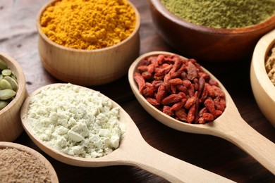 Photo of Different superfood products on wooden table, closeup