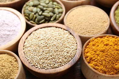Photo of Different superfoods in bowls on table, closeup