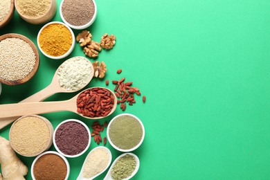 Photo of Different superfood products on green background, flat lay. Space for text