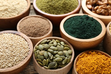 Photo of Different superfood products in bowls on table, closeup