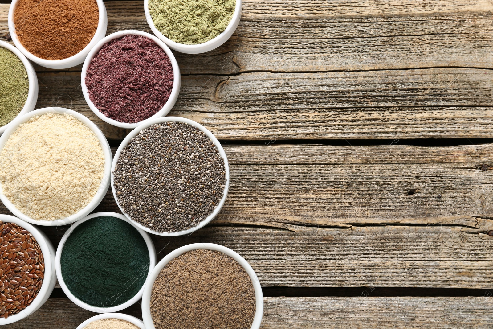 Different superfoods in bowls on wooden table, flat lay. Space for text Photo of Different superfoods in bowls on wooden table, flat lay. Space for text