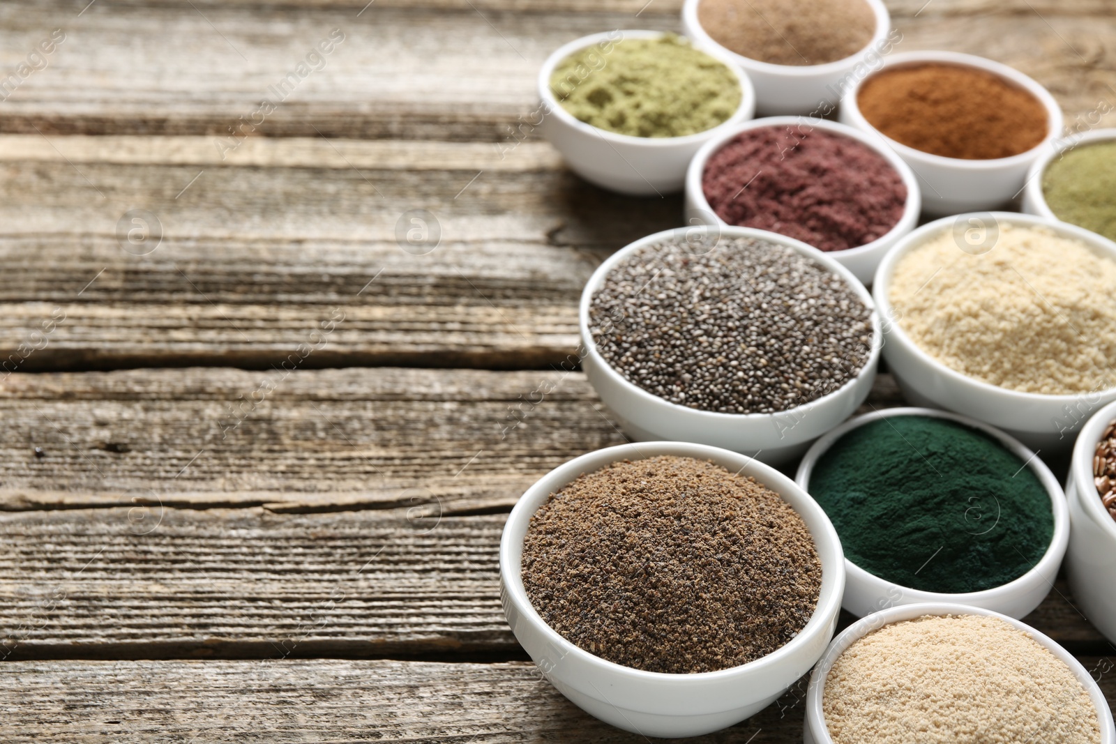 Different superfoods in bowls on wooden table, closeup. Space for text Photo of Different superfoods in bowls on wooden table, closeup. Space for text