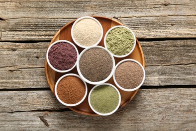 Photo of Different superfoods in bowls on wooden table, top view