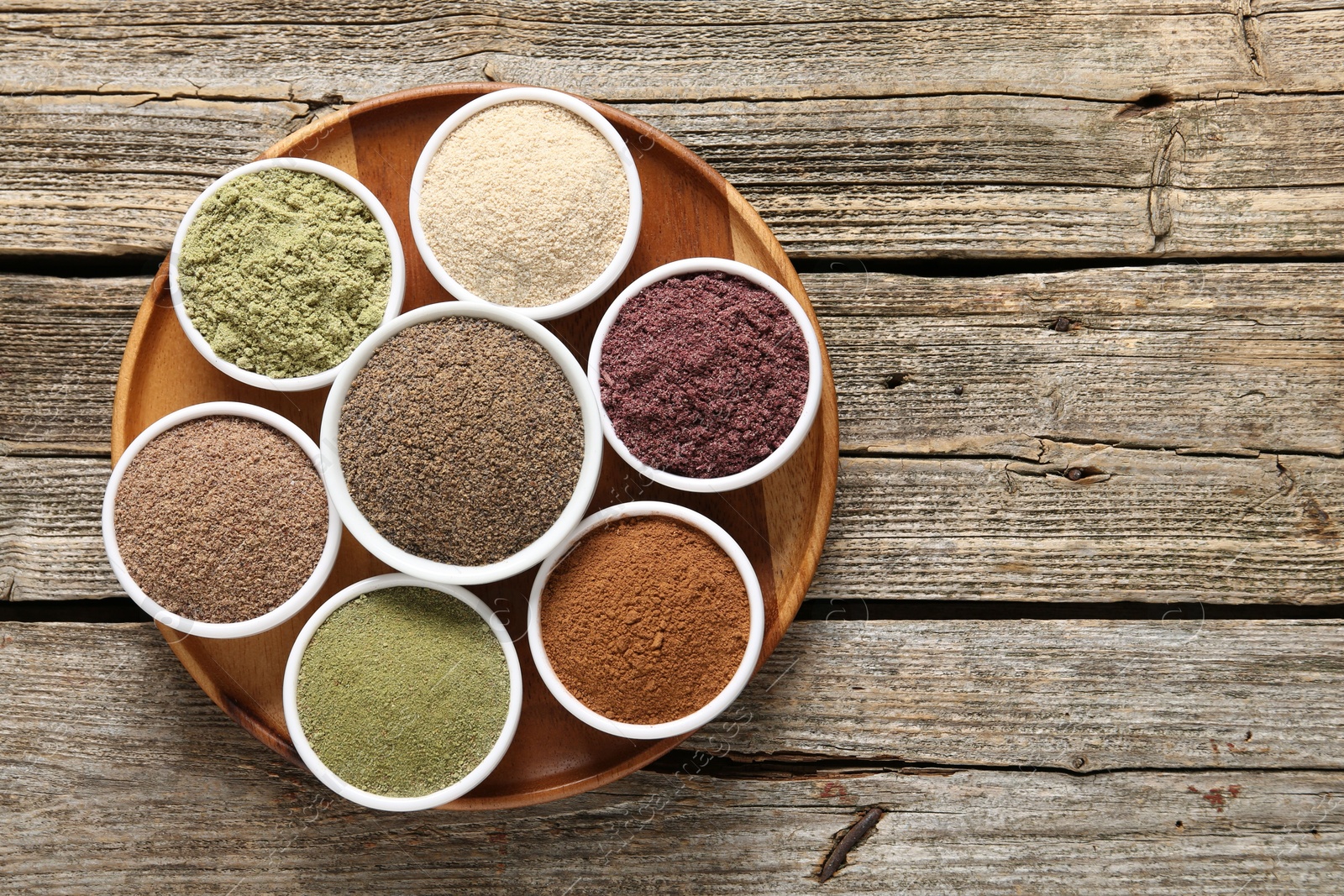 Different superfoods in bowls on wooden table, top view. Space for text Photo of Different superfoods in bowls on wooden table, top view. Space for text