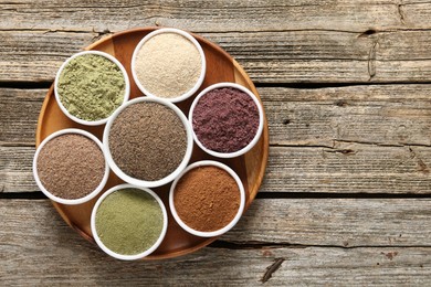 Photo of Different superfoods in bowls on wooden table, top view. Space for text