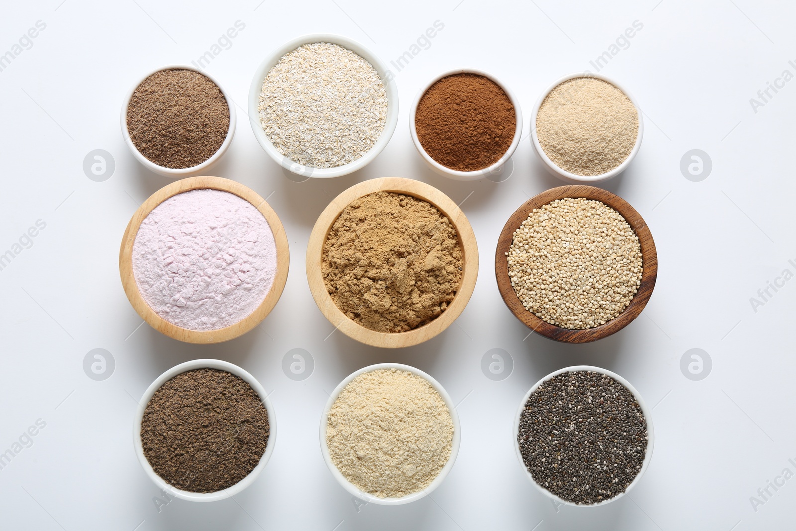 Different superfood powders in bowls on white background, flat lay Photo of Different superfood powders in bowls on white background, flat lay
