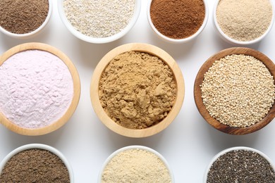Photo of Different superfood powders in bowls on white background, flat lay
