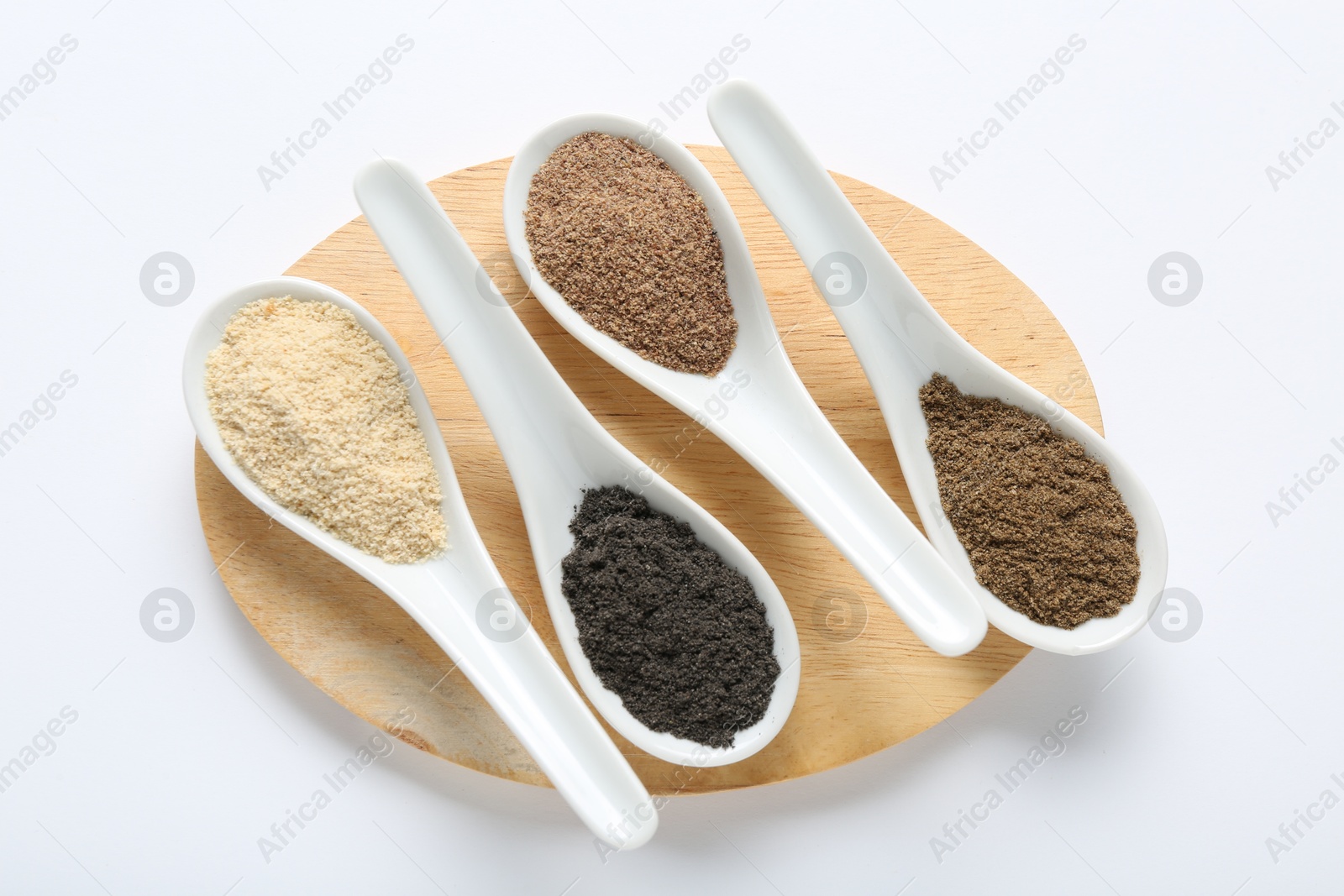 Different superfood powders in spoons on white background, top view Photo of Different superfood powders in spoons on white background, top view