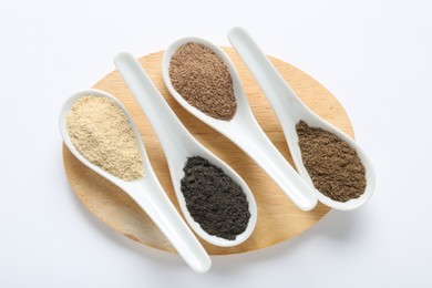 Photo of Different superfood powders in spoons on white background, top view