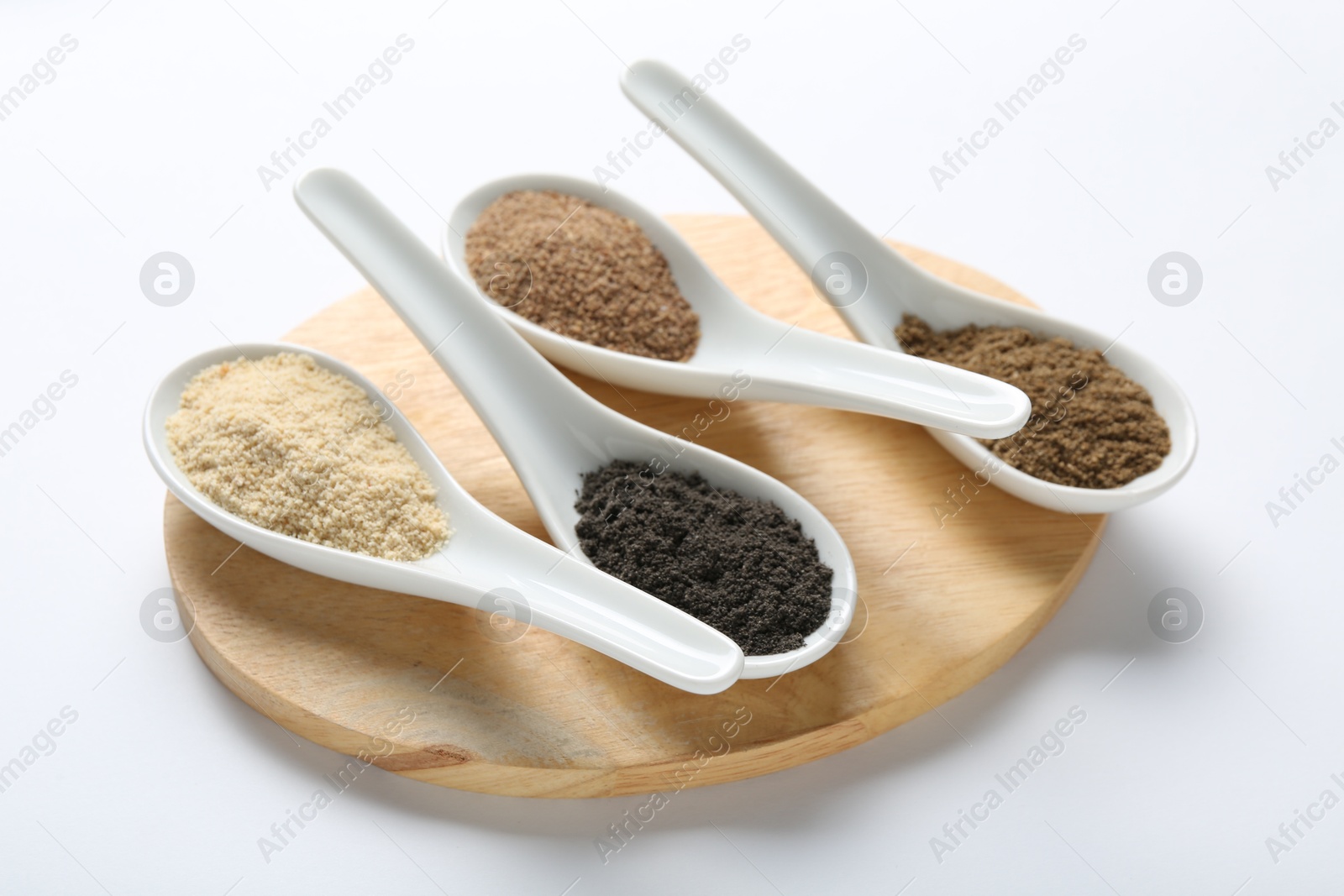 Different superfood powders in spoons on white background, closeup Photo of Different superfood powders in spoons on white background, closeup