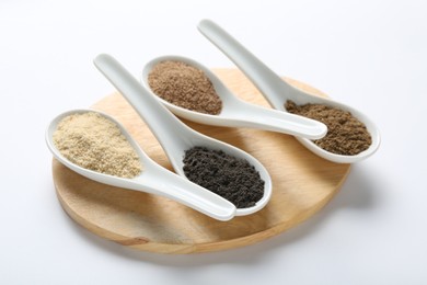 Photo of Different superfood powders in spoons on white background, closeup