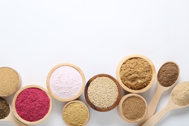 Photo of Different superfood powders in bowls and spoons on white background, flat lay. Space for text