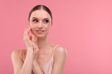 Photo of Portrait of beautiful young woman on pink background, space for text