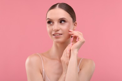 Photo of Portrait of beautiful young woman on pink background