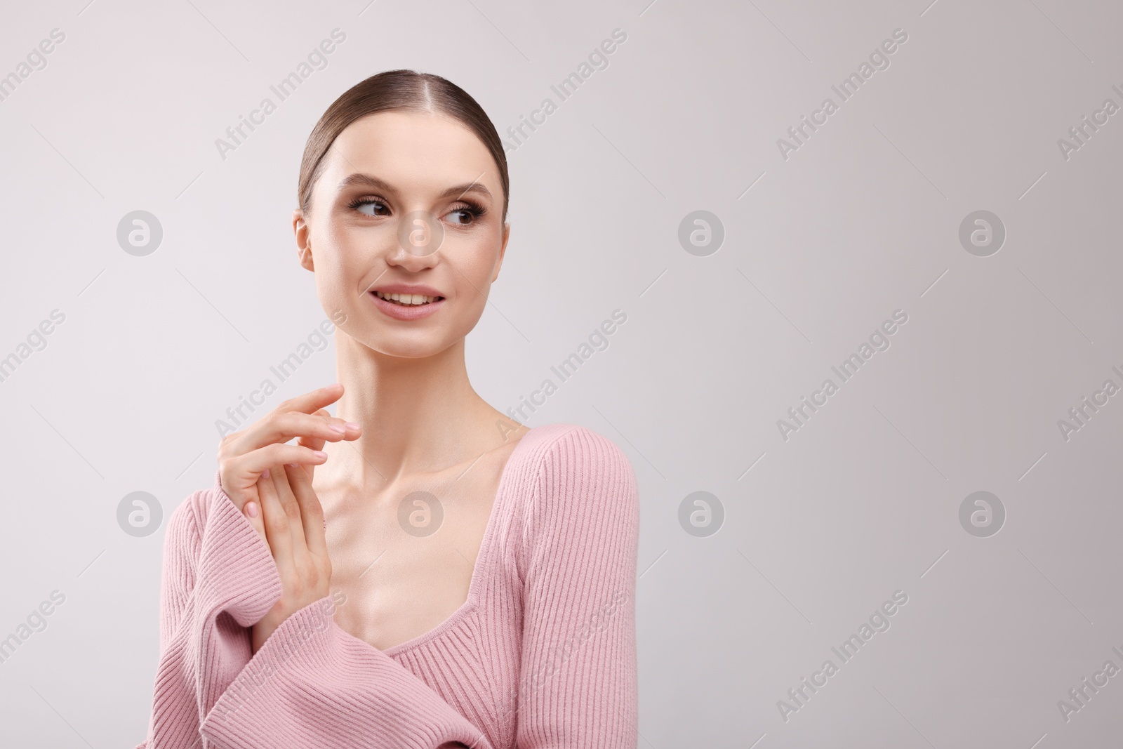 Portrait of beautiful young woman on gray background, space for text Photo of Portrait of beautiful young woman on gray background, space for text