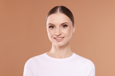 Photo of Portrait of beautiful young woman on beige background