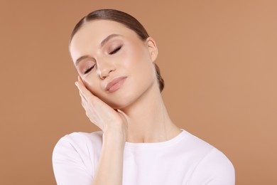 Photo of Portrait of beautiful young woman on beige background
