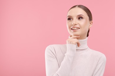 Photo of Portrait of beautiful young woman on pink background, space for text