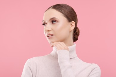Photo of Portrait of beautiful young woman on pink background,
