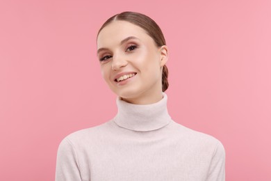Photo of Portrait of beautiful young woman on pink background,