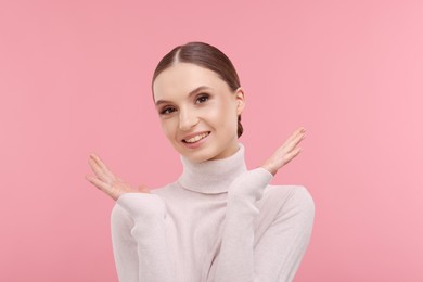 Photo of Portrait of beautiful young woman on pink background,