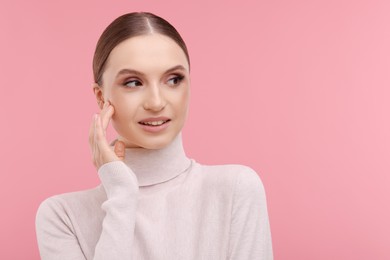 Photo of Portrait of beautiful young woman on pink background, space for text