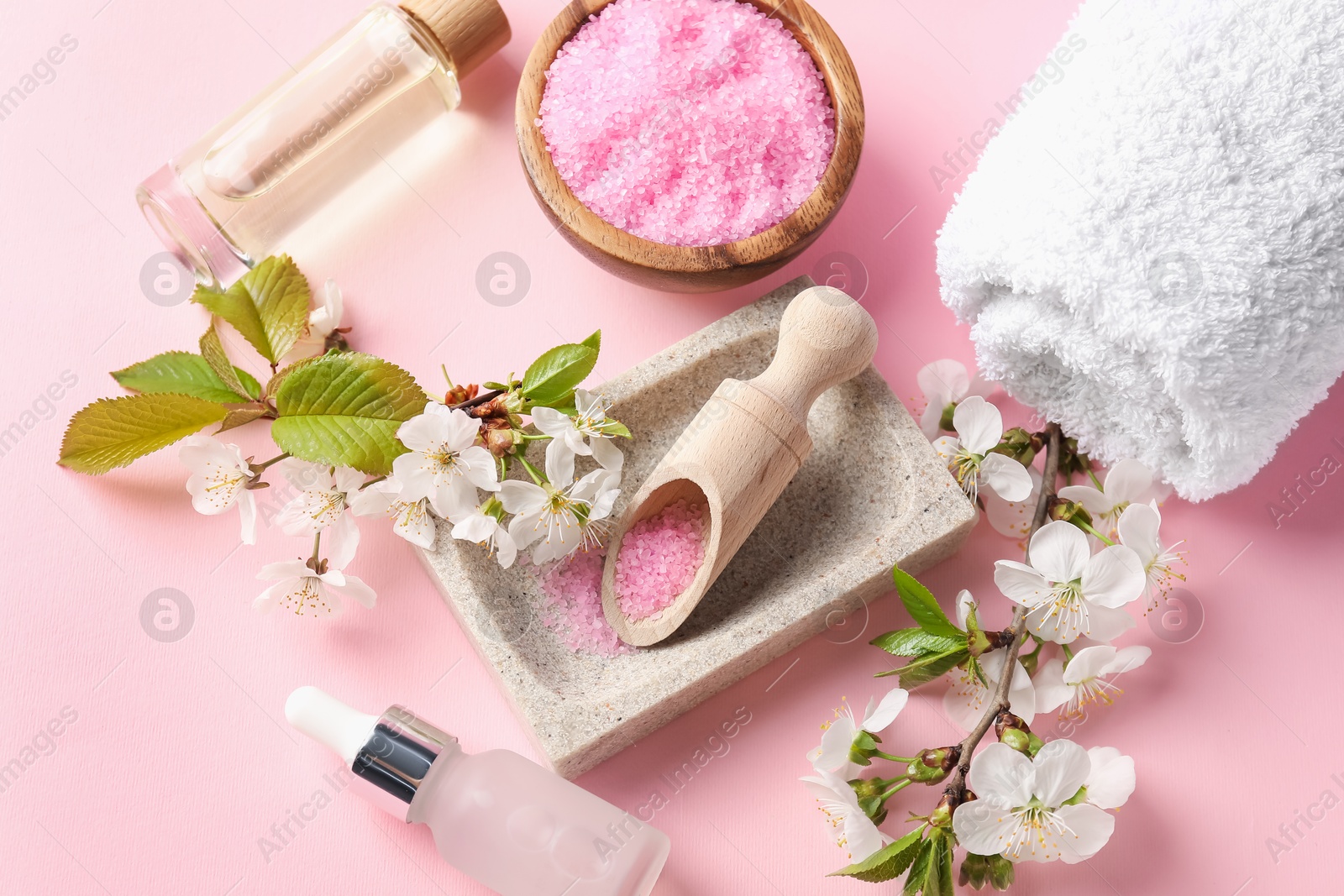 Spa composition with cosmetic products and beautiful flowers on pink background, flat lay Photo of Spa composition with cosmetic products and beautiful flowers on pink background, flat lay