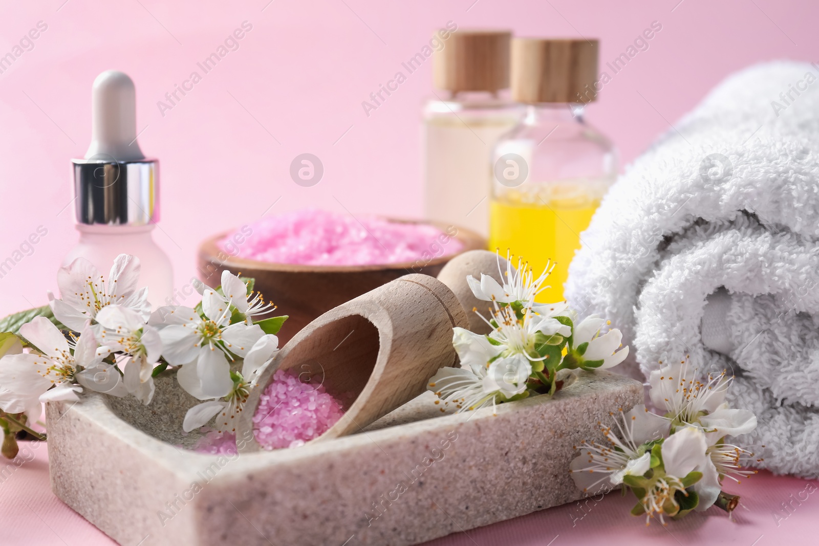Spa composition with cosmetic products and beautiful flowers on pink background, closeup Photo of Spa composition with cosmetic products and beautiful flowers on pink background, closeup