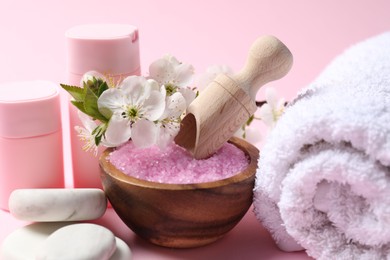 Photo of Spa composition with cosmetic products, pebble stones and beautiful flowers on pink background, closeup