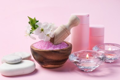 Photo of Spa composition with cosmetic products, pebble stones and beautiful flowers on pink background, closeup
