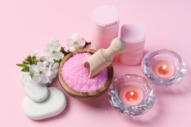 Photo of Spa composition with cosmetic products, pebble stones and beautiful flowers on pink background, above view