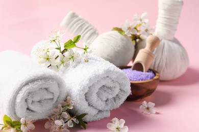Photo of Spa composition with towels and beautiful flowers on pink background, closeup