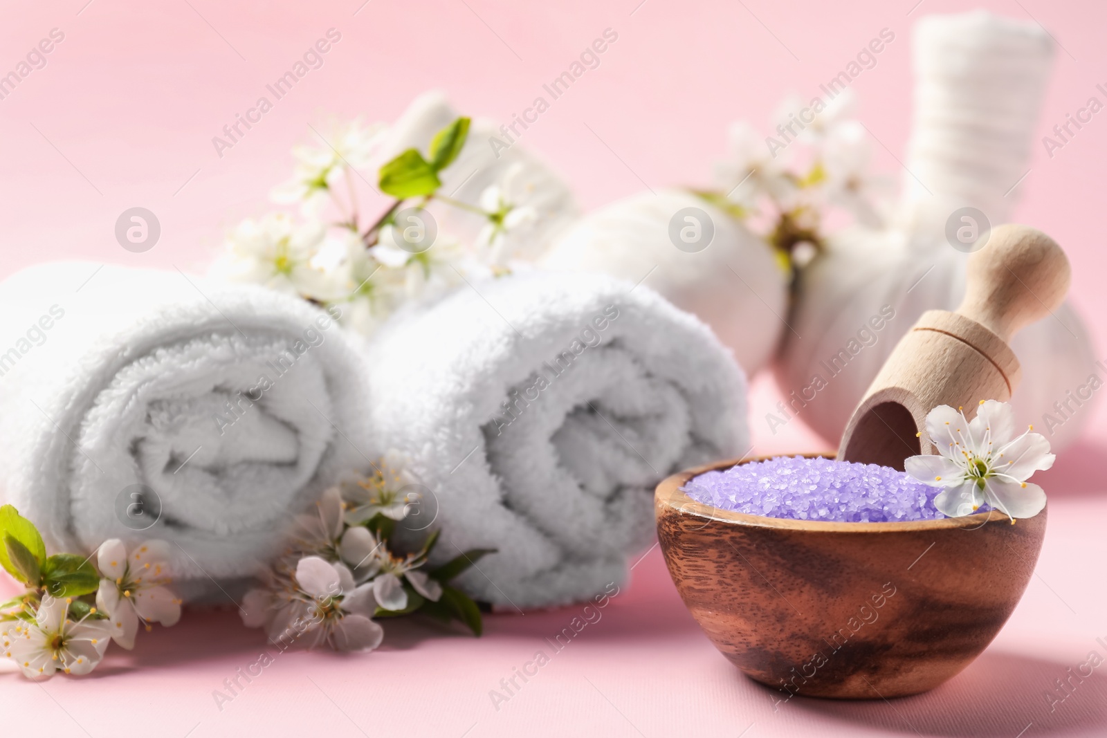 Spa composition with sea salt and beautiful flowers on pink background, closeup Photo of Spa composition with sea salt and beautiful flowers on pink background, closeup