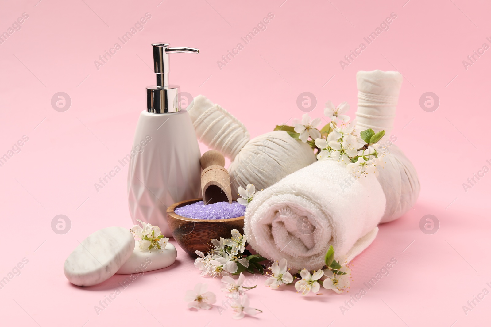 Spa composition with pebble stones and beautiful flowers on pink background, closeup Photo of Spa composition with pebble stones and beautiful flowers on pink background, closeup