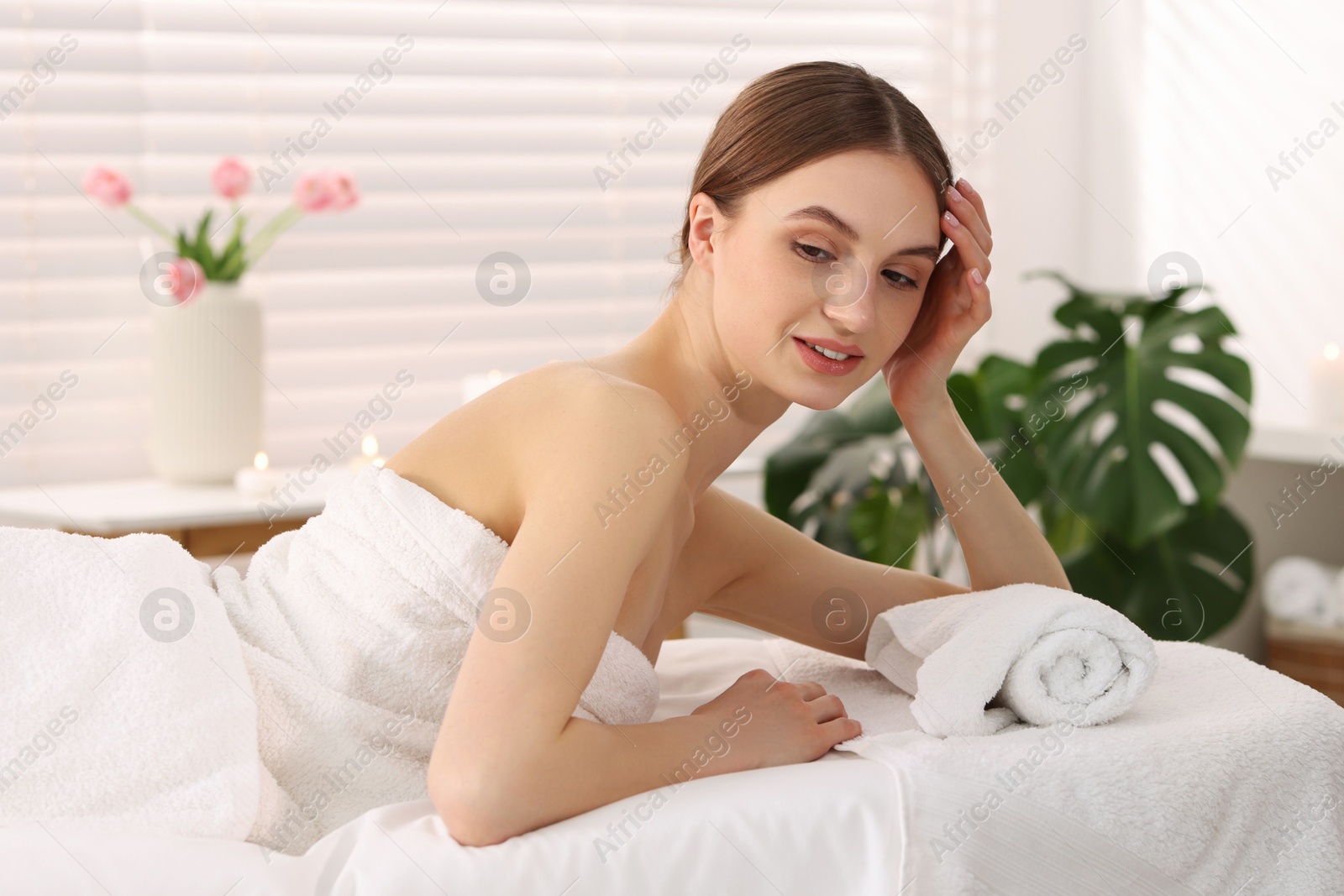 Beautiful woman relaxing on massage couch in spa salon Photo of Beautiful woman relaxing on massage couch in spa salon