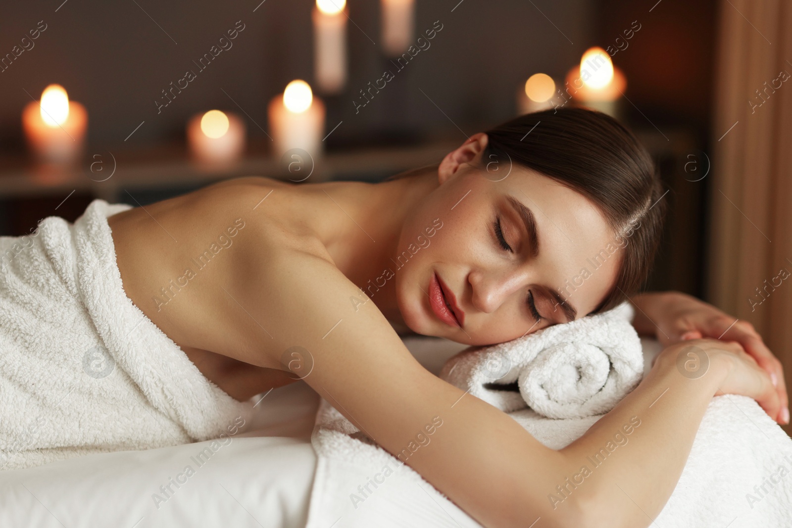 Beautiful woman relaxing on massage couch in spa salon Photo of Beautiful woman relaxing on massage couch in spa salon