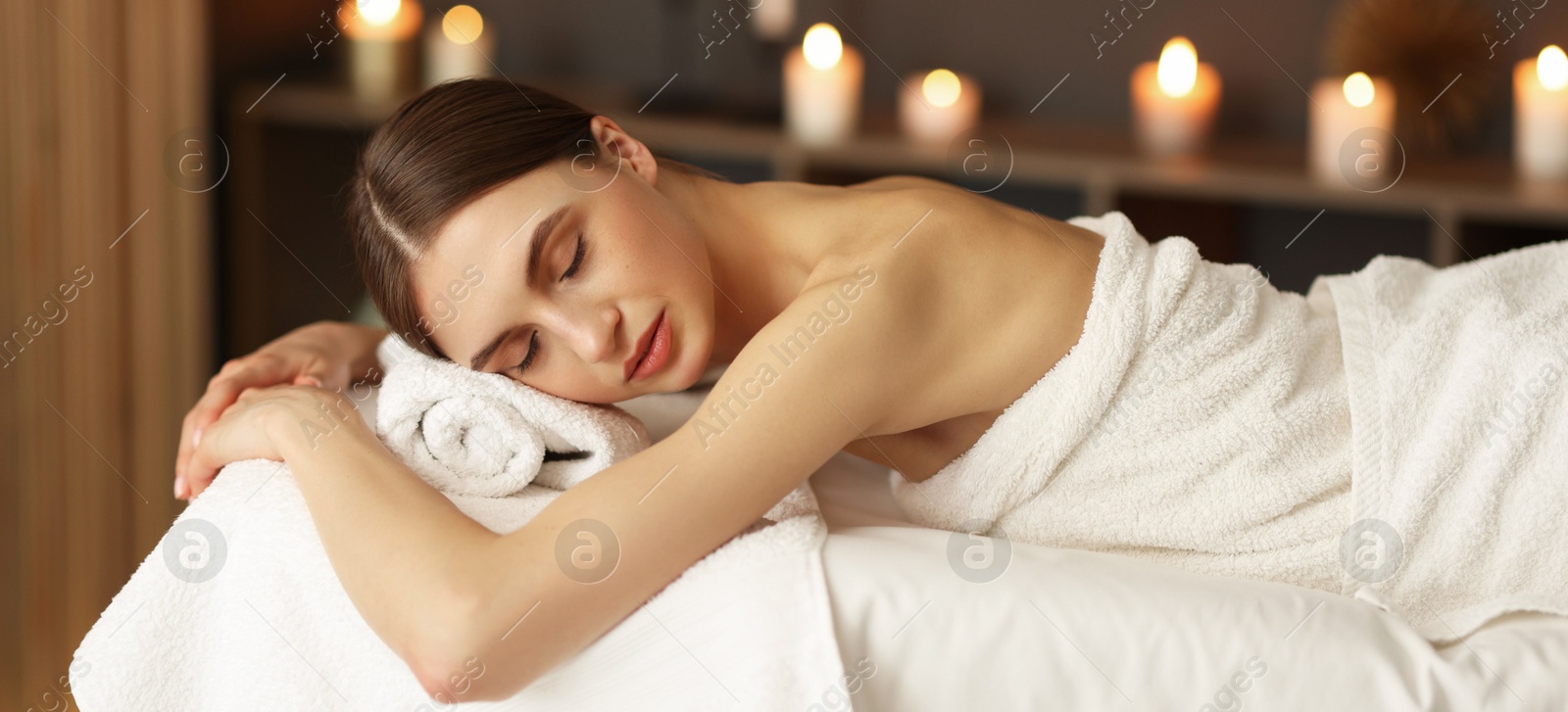 Beautiful woman relaxing on massage couch in spa salon Photo of Beautiful woman relaxing on massage couch in spa salon