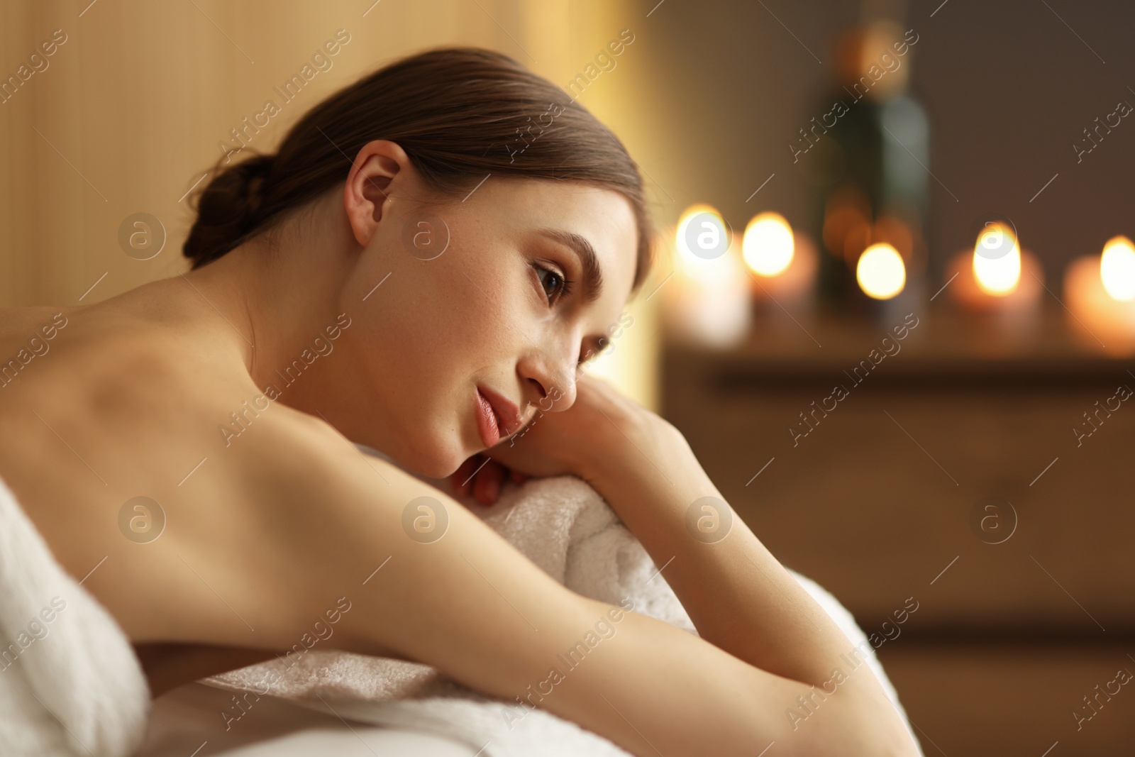 Beautiful woman relaxing on massage couch in spa salon Photo of Beautiful woman relaxing on massage couch in spa salon