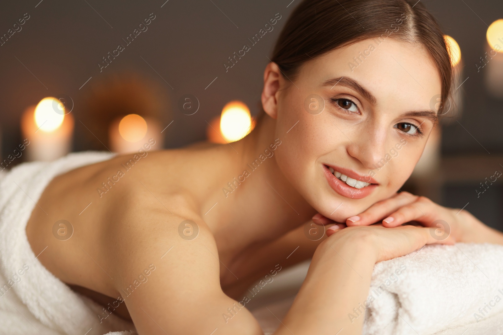 Smiling woman relaxing on massage couch in spa salon Photo of Smiling woman relaxing on massage couch in spa salon