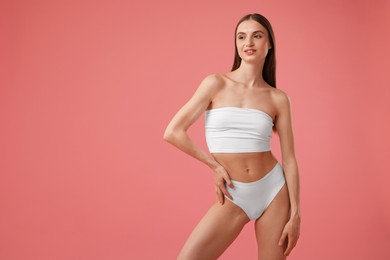 Photo of Beautiful woman with perfect slim body on pink background. Space for text