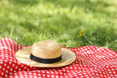 Photo of Straw hat and blanket on green grass outdoors Space for text