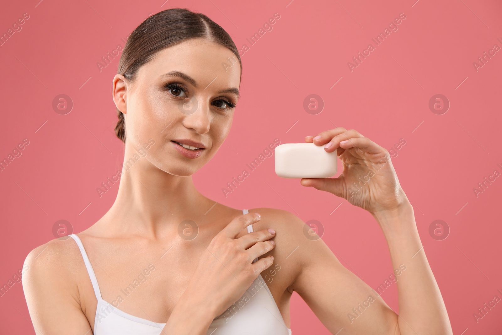 Beautiful woman with soap bar on pink background Photo of Beautiful woman with soap bar on pink background