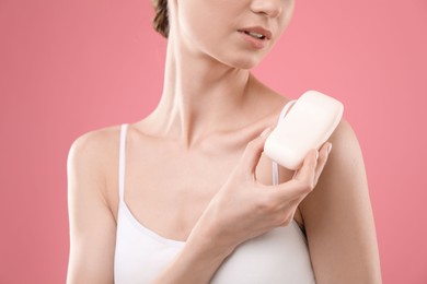 Photo of Woman with soap bar on pink background, closeup