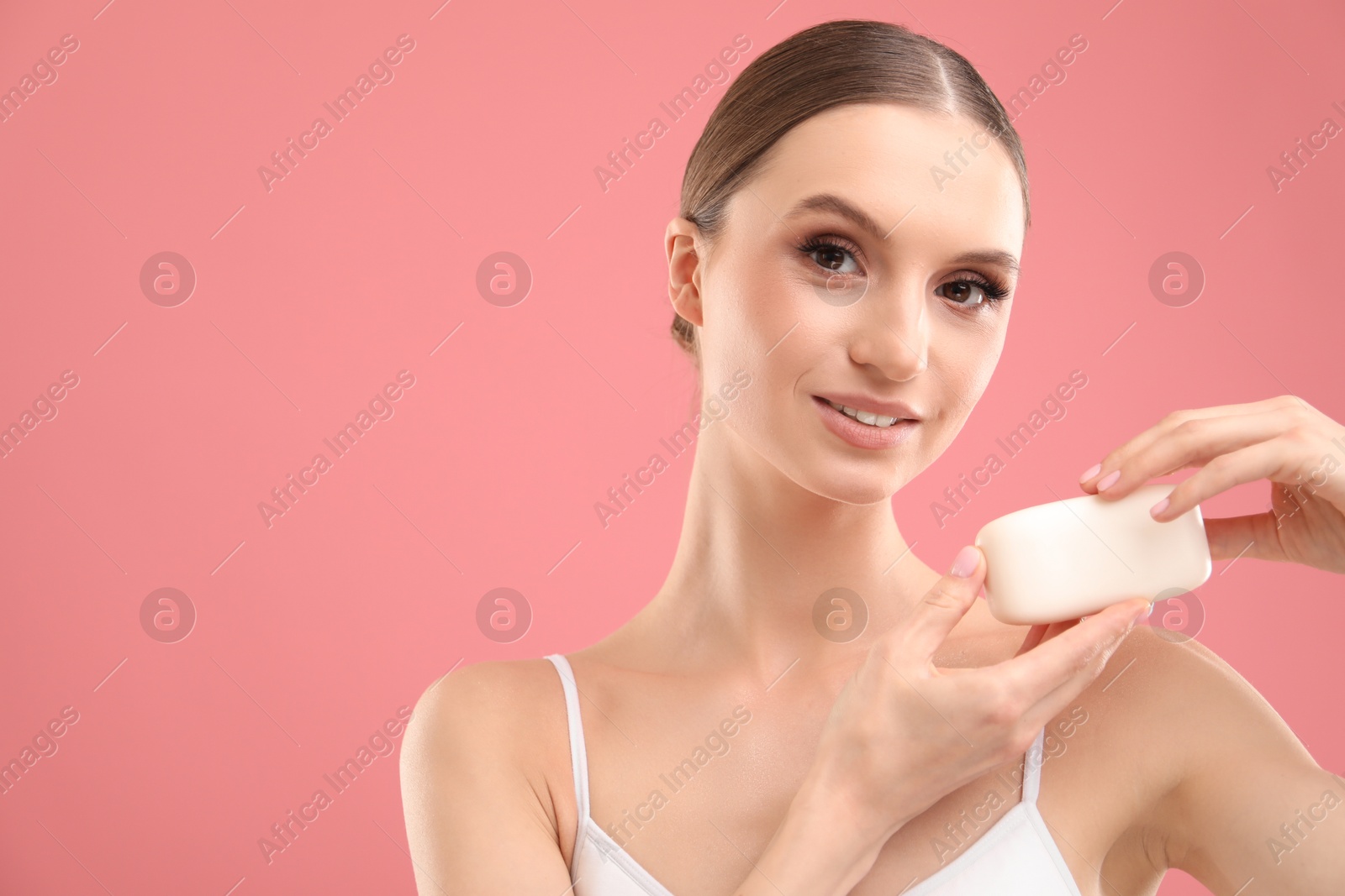 Smiling woman with soap bar on pink background. Space for text Photo of Smiling woman with soap bar on pink background. Space for text