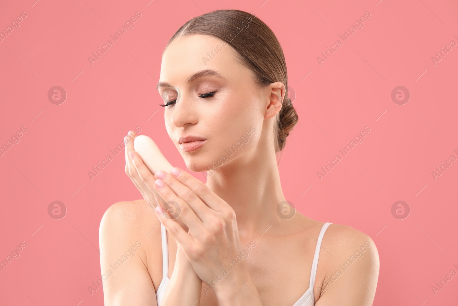 Beautiful woman with soap bar on pink background Photo of Beautiful woman with soap bar on pink background