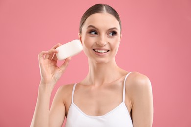 Photo of Smiling woman with soap bar on pink background