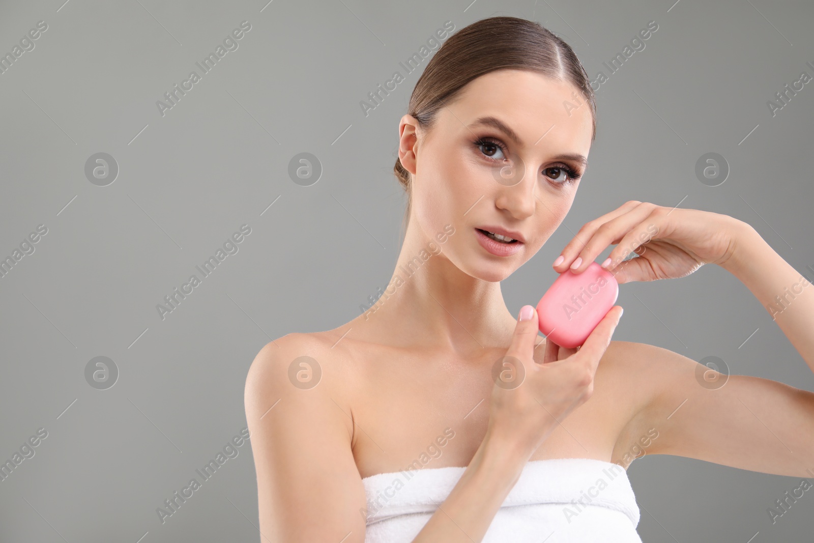 Beautiful woman with soap bar on grey background. Space for text Photo of Beautiful woman with soap bar on grey background. Space for text