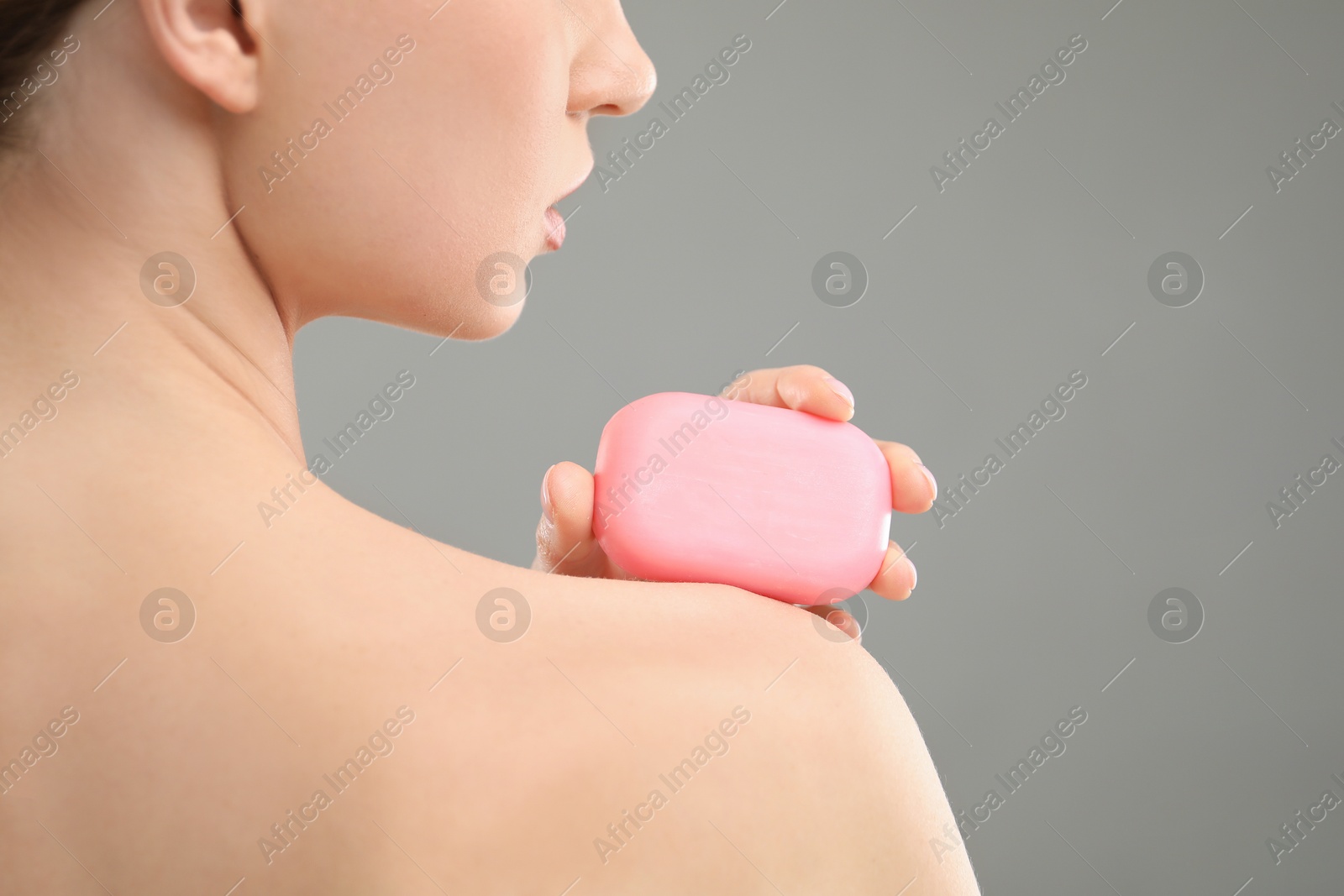 Woman with soap bar on grey background, closeup Photo of Woman with soap bar on grey background, closeup